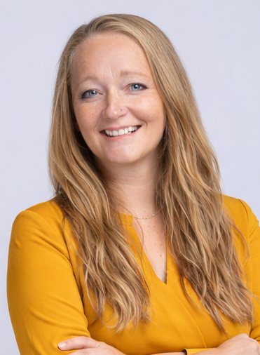Kristen B. Lenzen, founder of The Soothing Spark, smiling with arms crossed