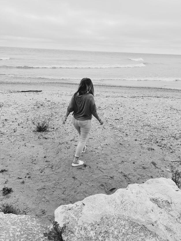 Kristen B. Lenzen walking toward the water, contemplative